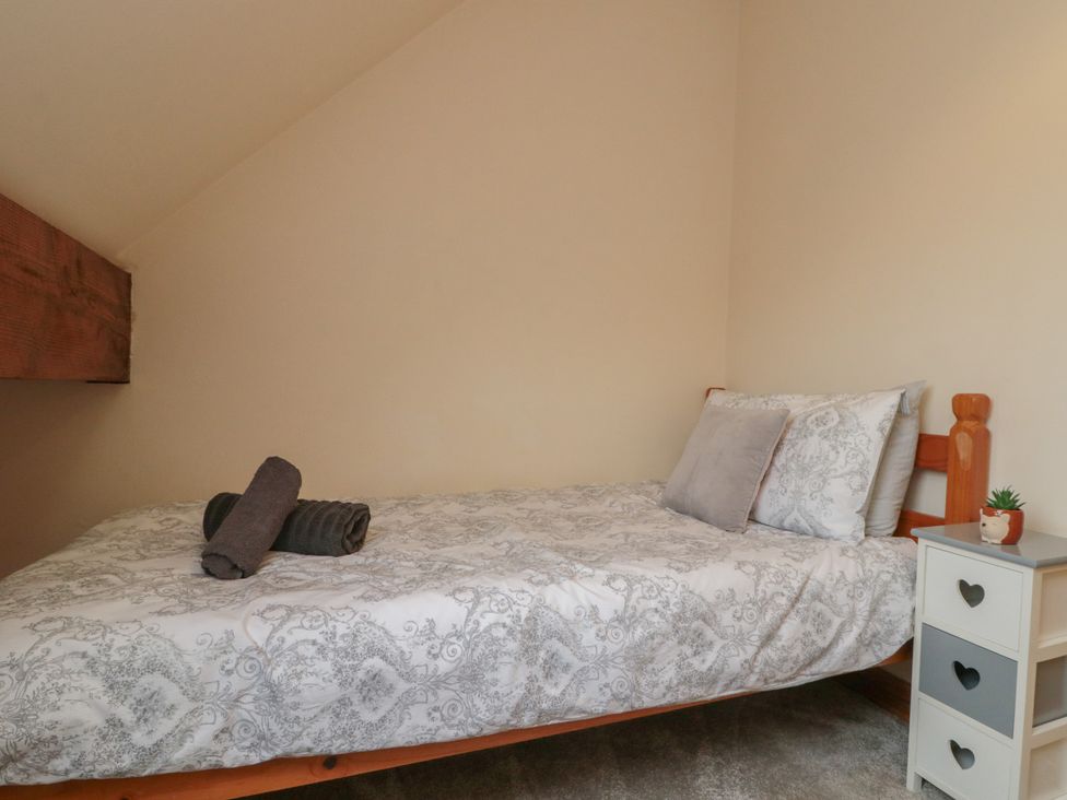 A bedroom with a bed and bedside table at Milton Cottage in Hawsker near Whitby and Robin Hood's Bay