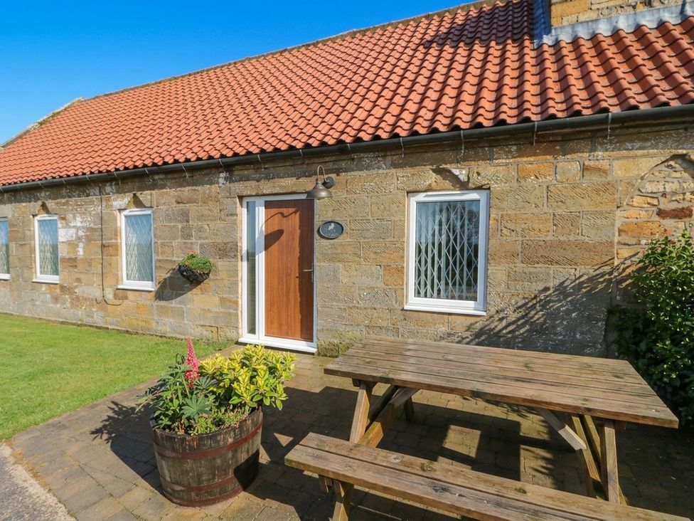 An outdoor area with a wooden table and planter at Milton Cottage Hawsker near Whitby and Robin Hood's Bay