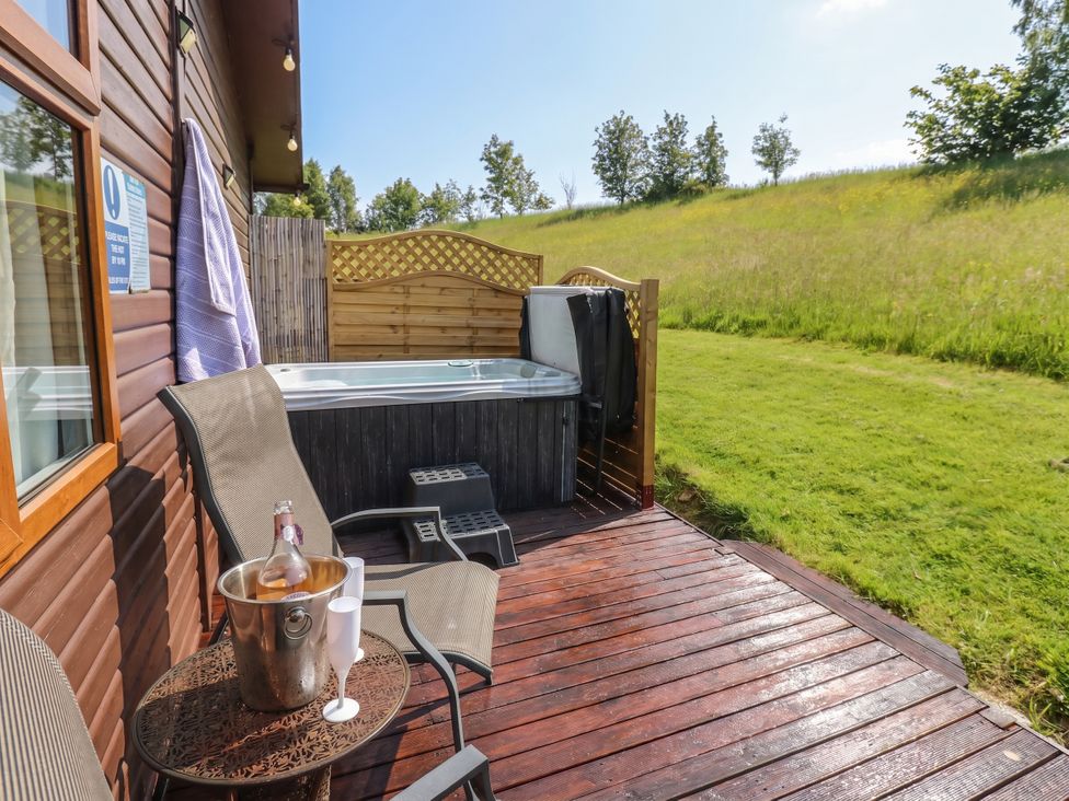 An outdoor patio with a hot tub and seating area at 16 Badgers Retreat in Richmond