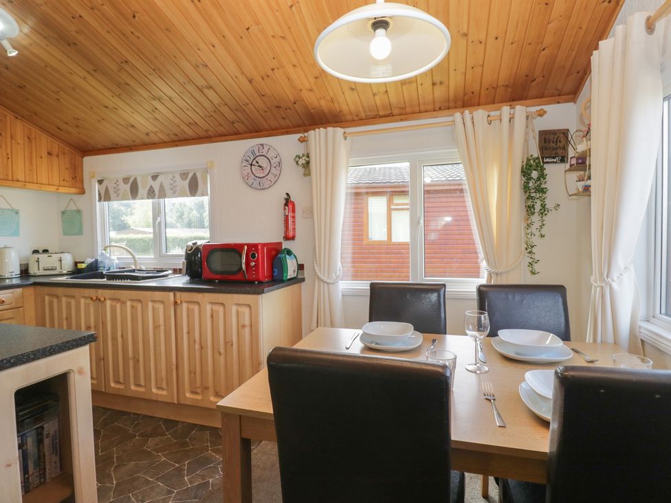 A kitchen with a dining table and chairs at The Cedars in South Lakeland Leisure Village