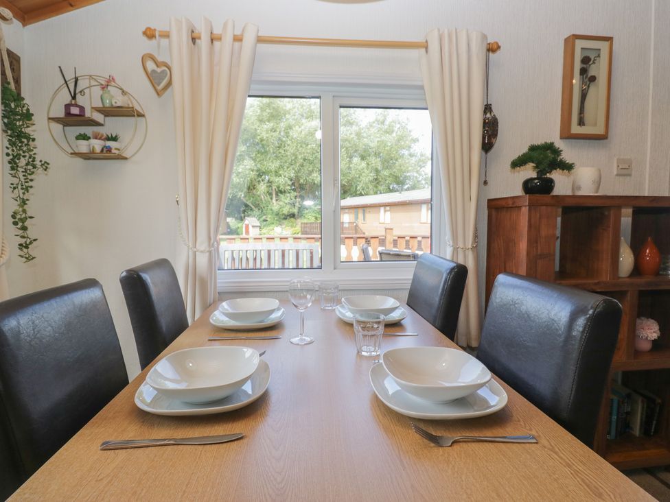 A dining room with a table set for meals at The Cedars in South Lakeland Leisure Village