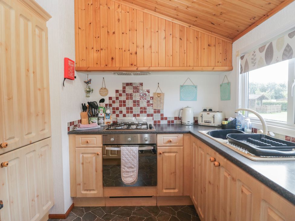 A kitchen with a stove and sink at The Cedars in South Lakeland Leisure Village