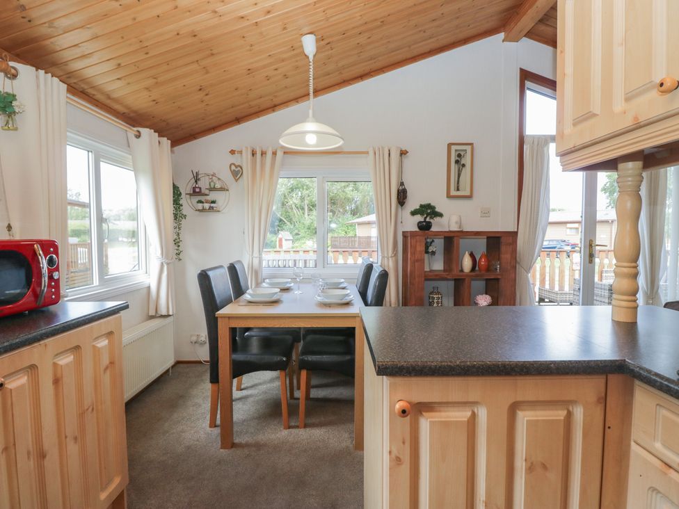 A kitchen with a dining table and chairs at The Cedars in South Lakeland Leisure Village