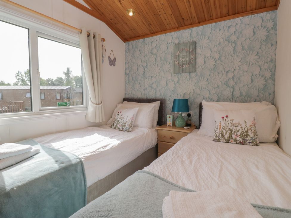 A bedroom with twin beds and a bedside table at The Cedars South Lakeland Leisure Village