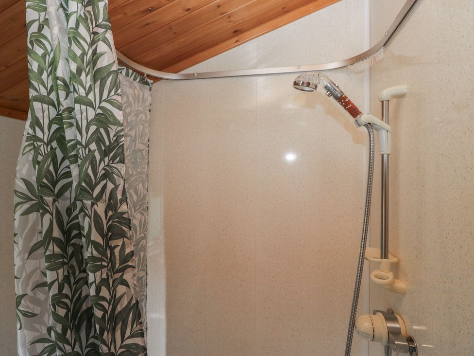 A shower with a curtain and controls at The Cedars South Lakeland Leisure Village