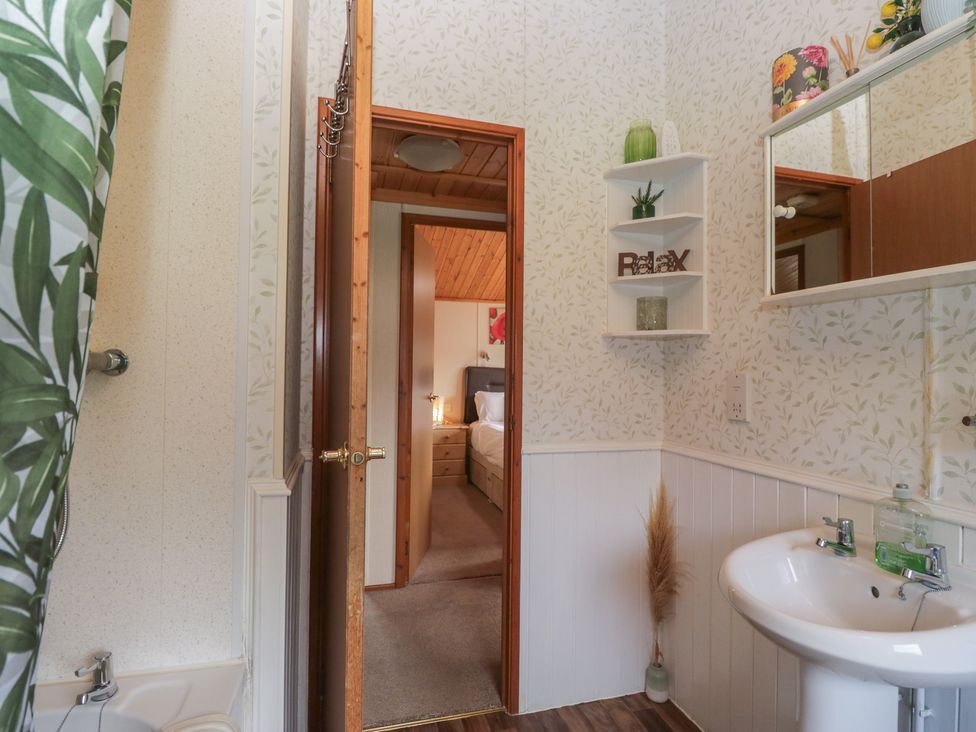 A bathroom with a bathtub and sink at The Cedars in South Lakeland Leisure Village