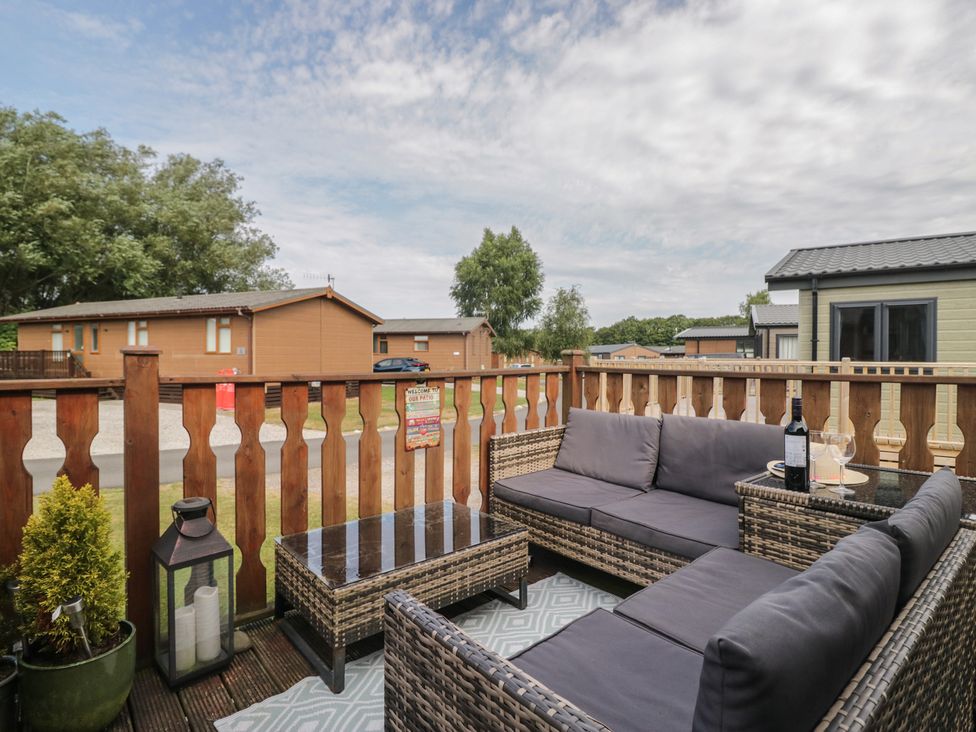 An outdoor seating area with a couch and table at The Cedars in South Lakeland Leisure Village