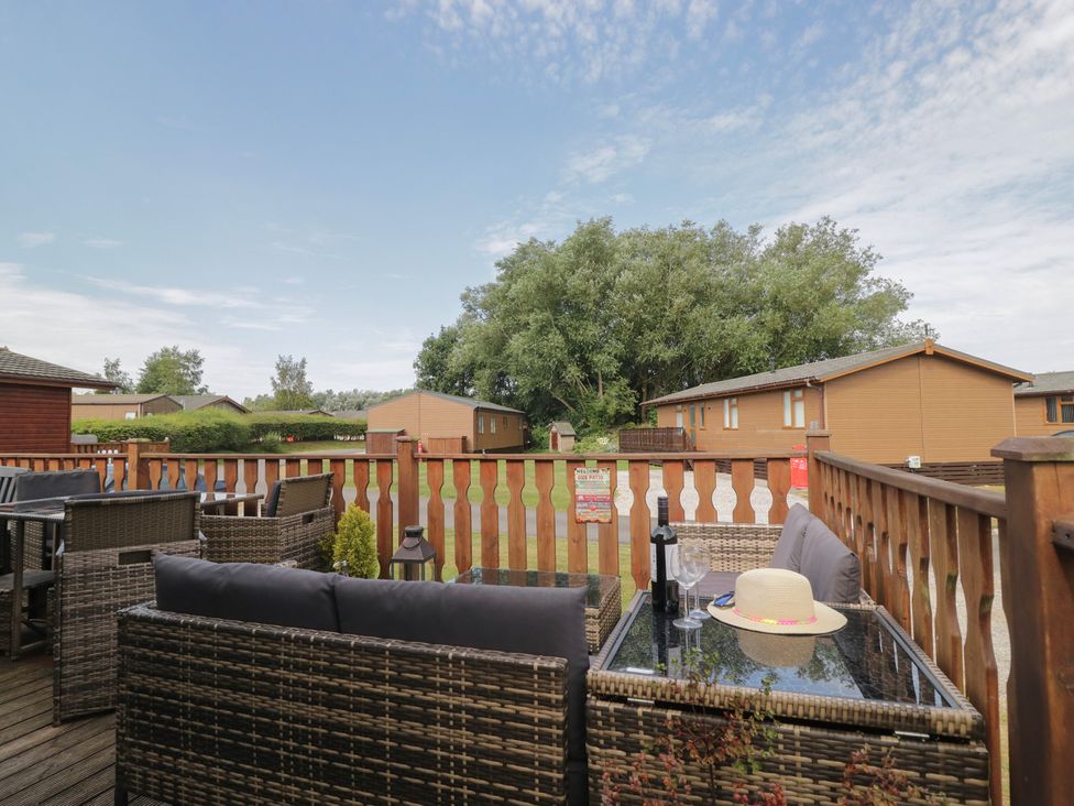 A seating area on a deck with a table and chairs at The Cedars South Lakeland Leisure Village