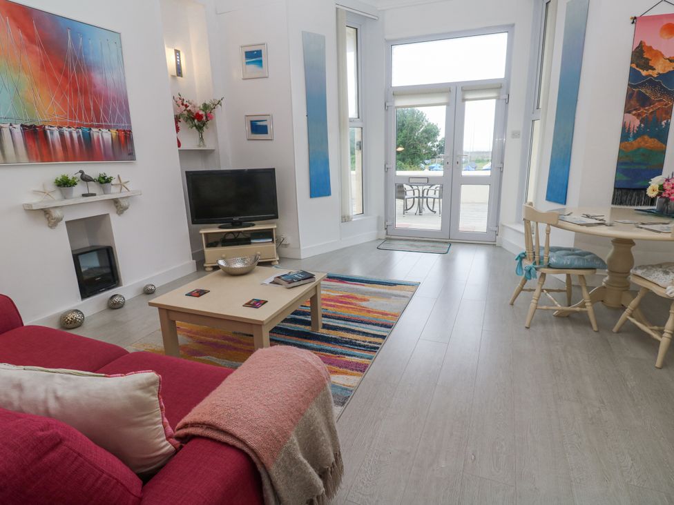 A living room with a television and dining table at Beachcomber in Marazion
