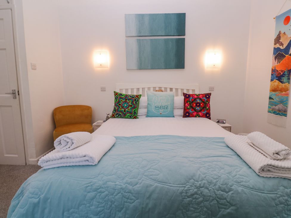 A bedroom with a bed and chair at Beachcomber in Marazion