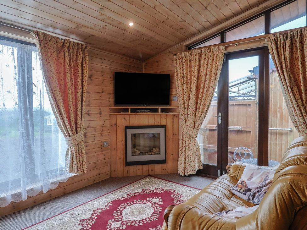 A snug with a television and fireplace at The Cabin at East Hill Pride Four Elms Hill Nr. Sidmouth