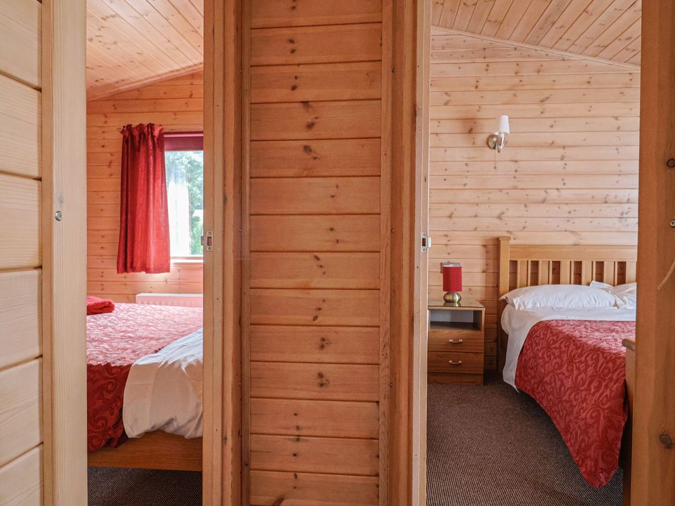 A bedroom with two beds and a window at The Cabin at East Hill Pride in Four Elms Hill Nr. Sidmouth