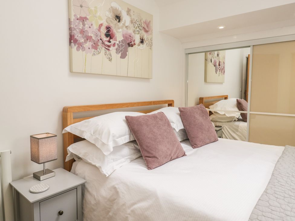 A bedroom with a bed and wall art at Coney Garth Barn in Beckermet