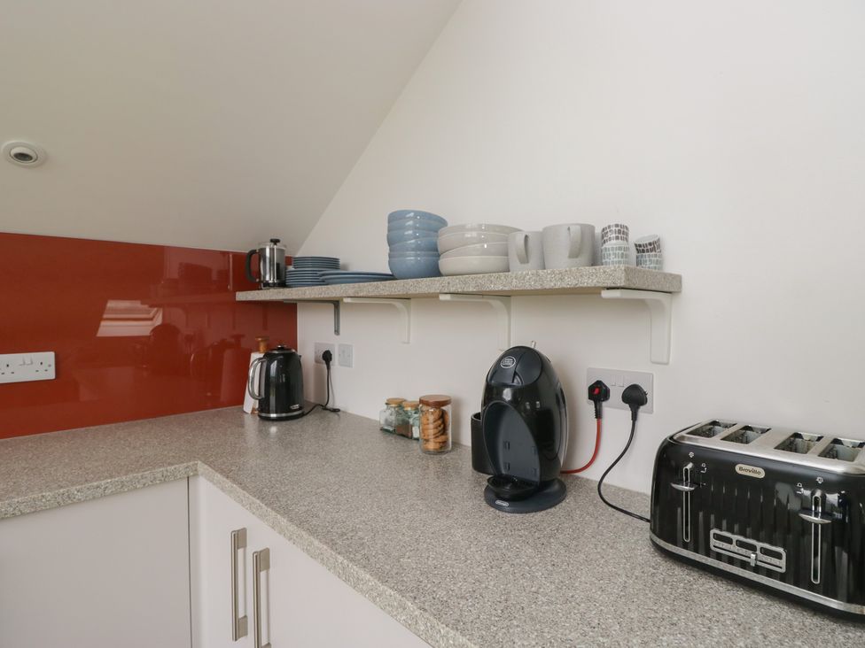 A kitchen with appliances and crockery at Coney Garth Retreat in Beckermet
