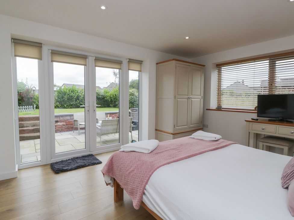 A bedroom with a bed and wardrobe at Coney Garth Retreat in Beckermet