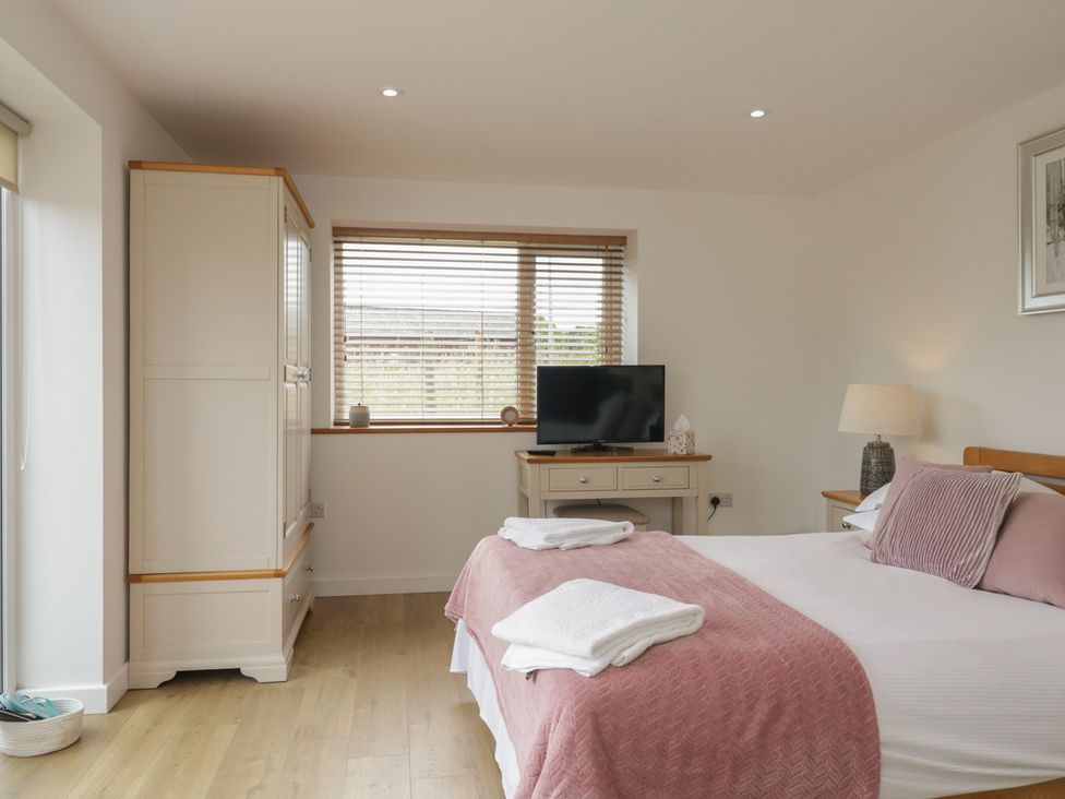 A bedroom with a bed and television at Coney Garth Retreat in Beckermet