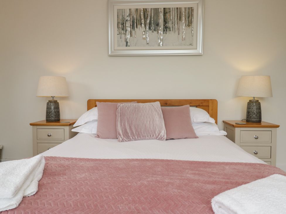 A bedroom with a bed and side tables at Coney Garth Retreat in Beckermet