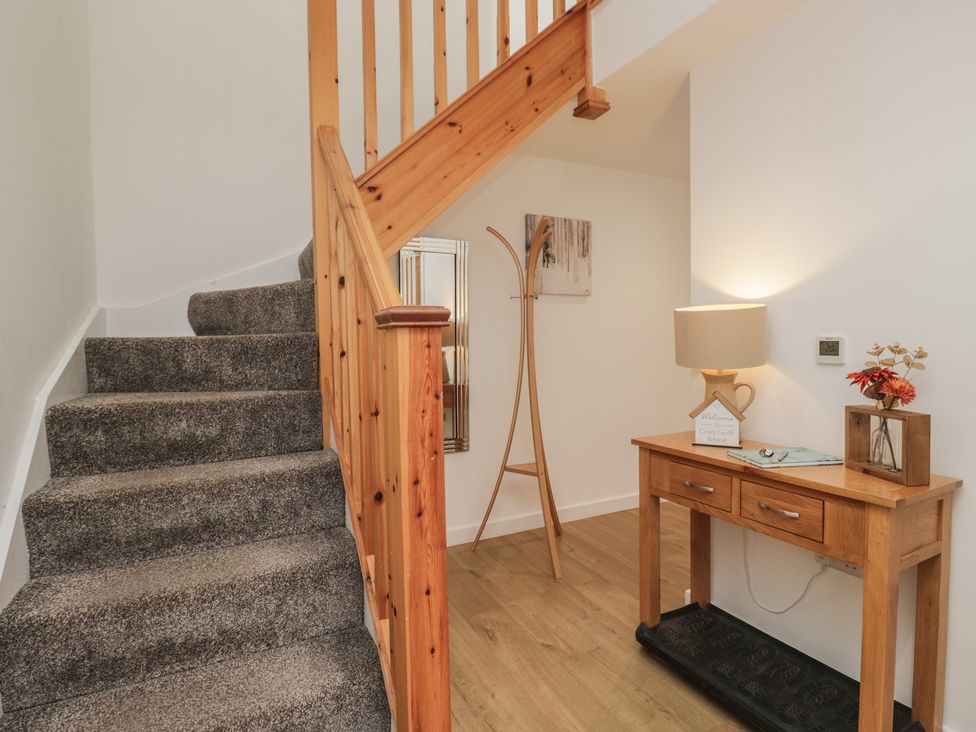 A hallway with stairs and a console table at Coney Garth Retreat in Beckermet