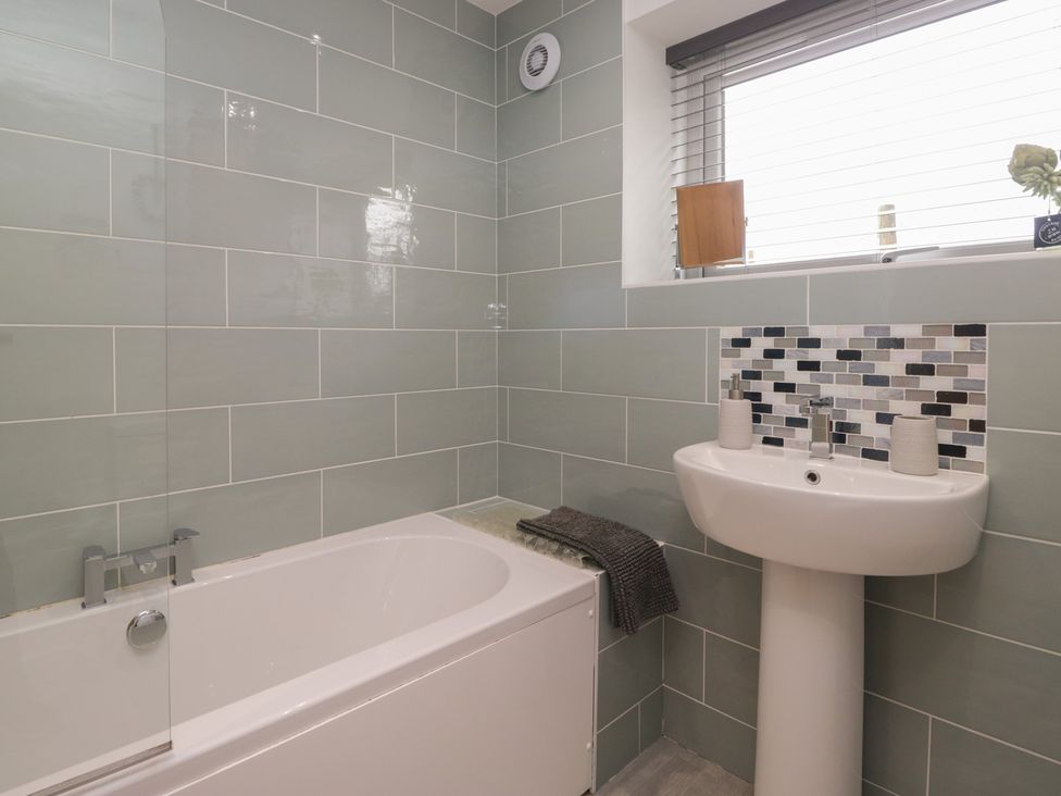 A bathroom with a bathtub and sink at Coney Garth Retreat in Beckermet