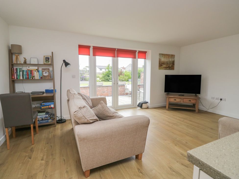 A living room with a sofa and television at Coney Garth Cottage in Beckermet