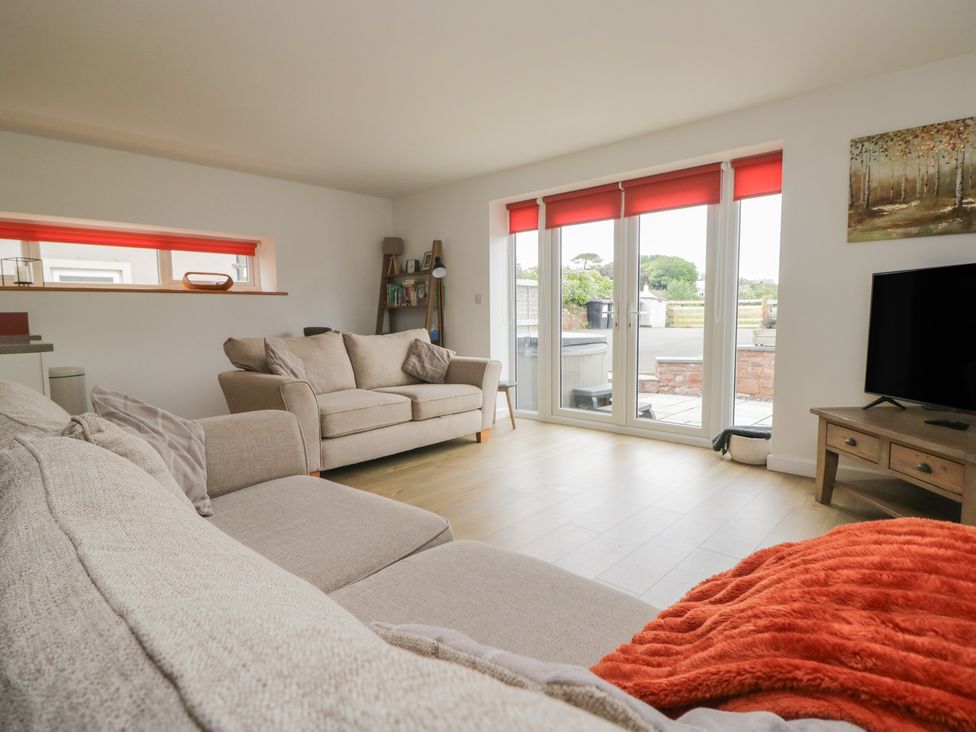 A living room with a sofa and a television at Coney Garth Cottage in Beckermet