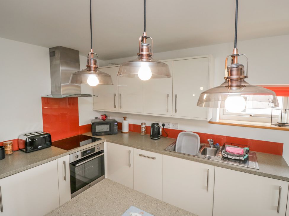 A kitchen with appliances and countertops at Coney Garth Cottage in Beckermet