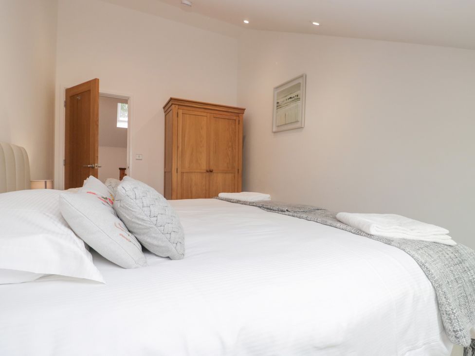 A bedroom with a bed and wardrobe at Coney Garth Cottage in Beckermet