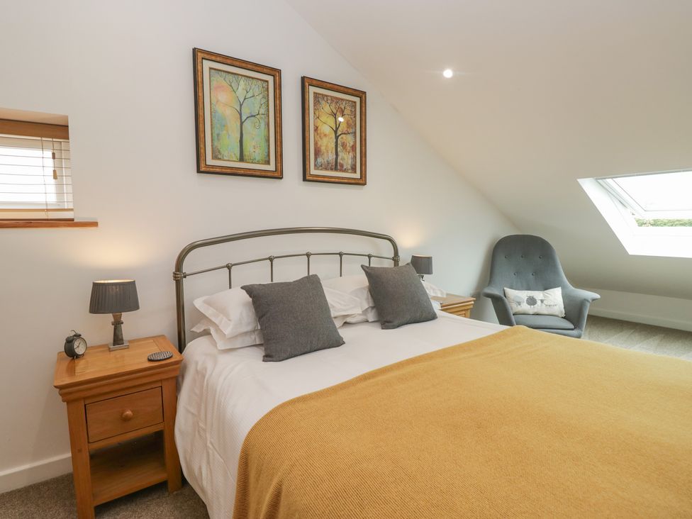 A bedroom with bed and bedside table at Coney Garth Cottage Beckermet