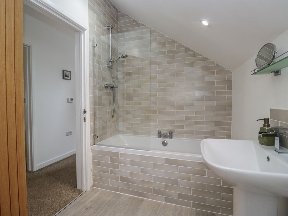 A bathroom with a bathtub and shower at Coney Garth Cottage in Beckermet