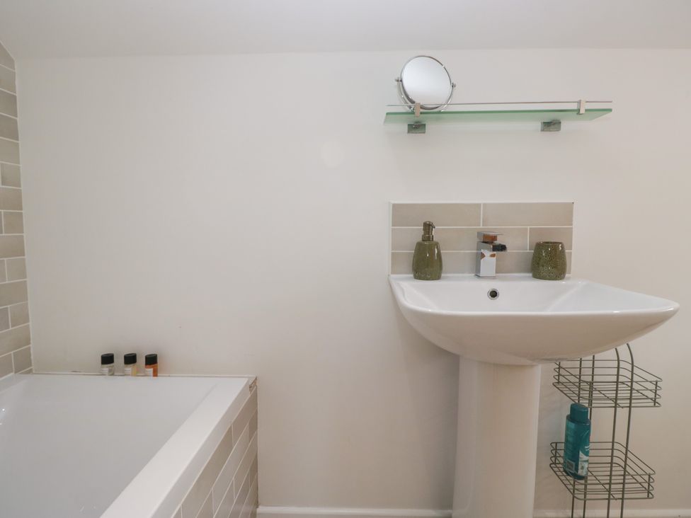 A bathroom with a bathtub and wash basin at Coney Garth Cottage in Beckermet