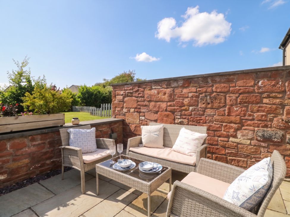 An outdoor seating area with furniture and plants at Coney Garth Cottage Beckermet