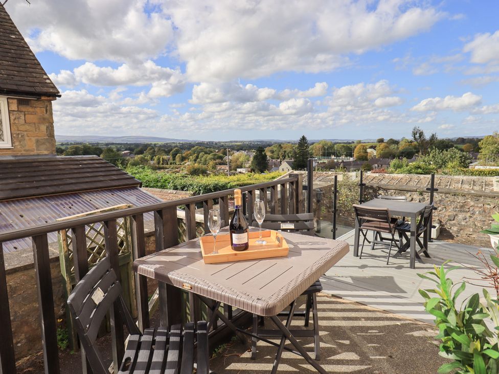 An outdoor seating area with a table and wine at The Cells Ingleton