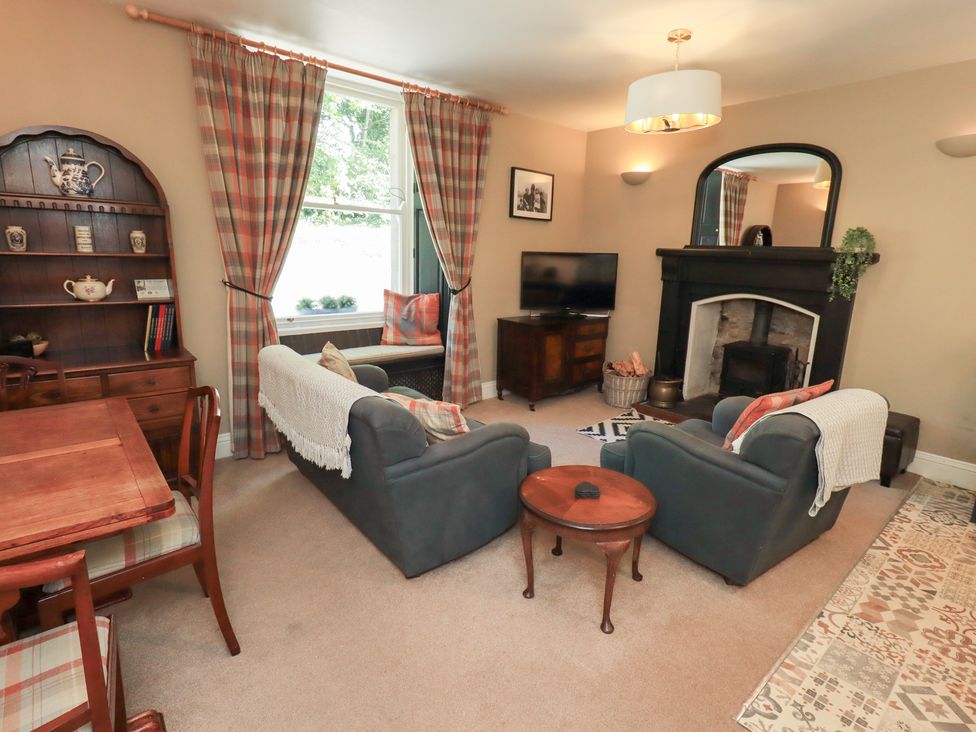 A living room with a sofa, coffee table, and television at The Cells in Ingleton