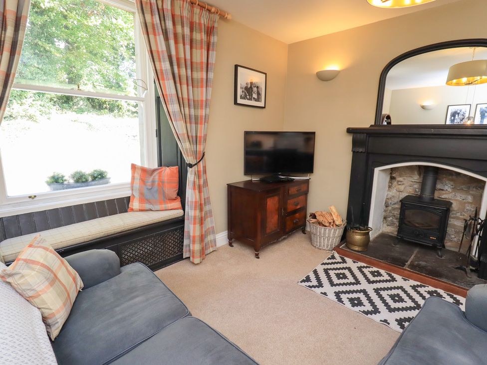 A living room with a sofa and a television at The Cells in Ingleton