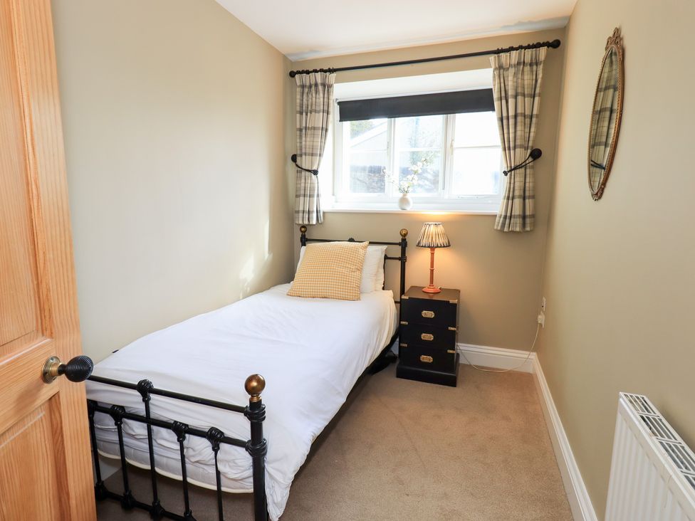 A bedroom with a single bed and a nightstand at The Cells in Ingleton