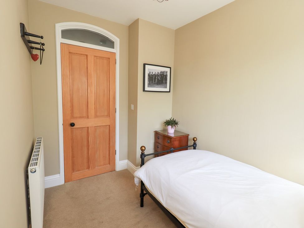 A bedroom with a bed and a wooden table at The Cells in Ingleton