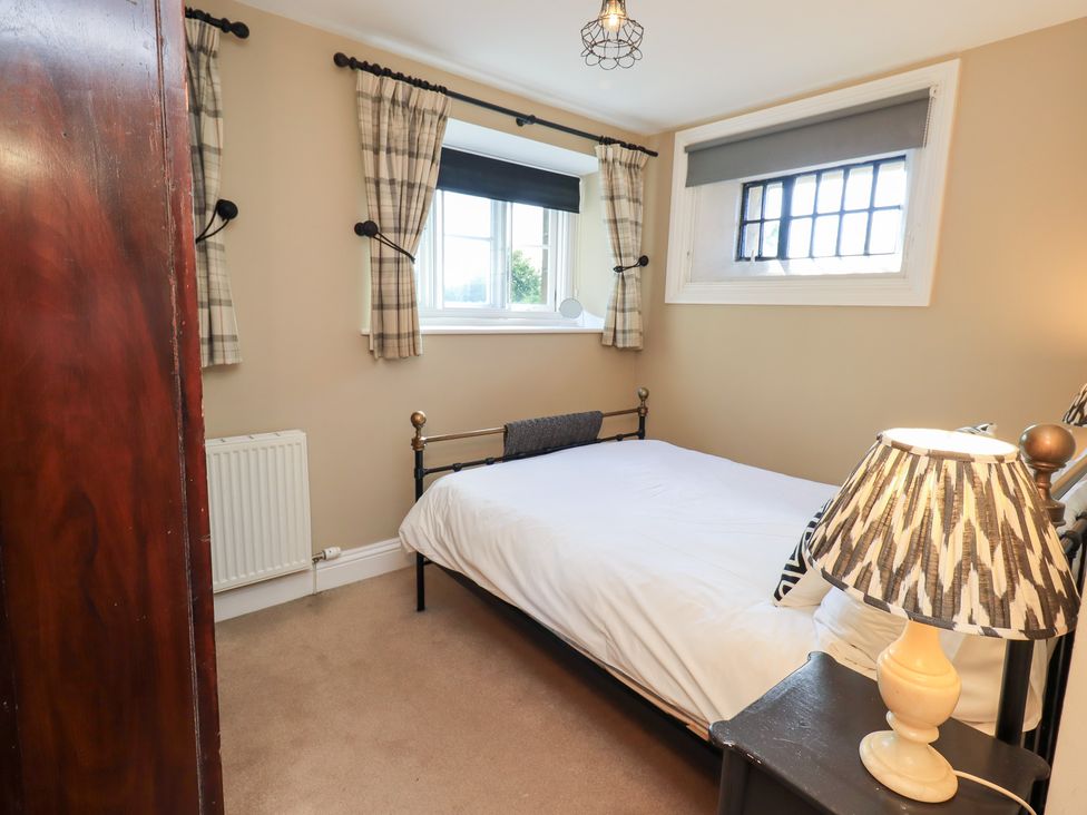 A bedroom with a bed and lamp at The Cells in Ingleton