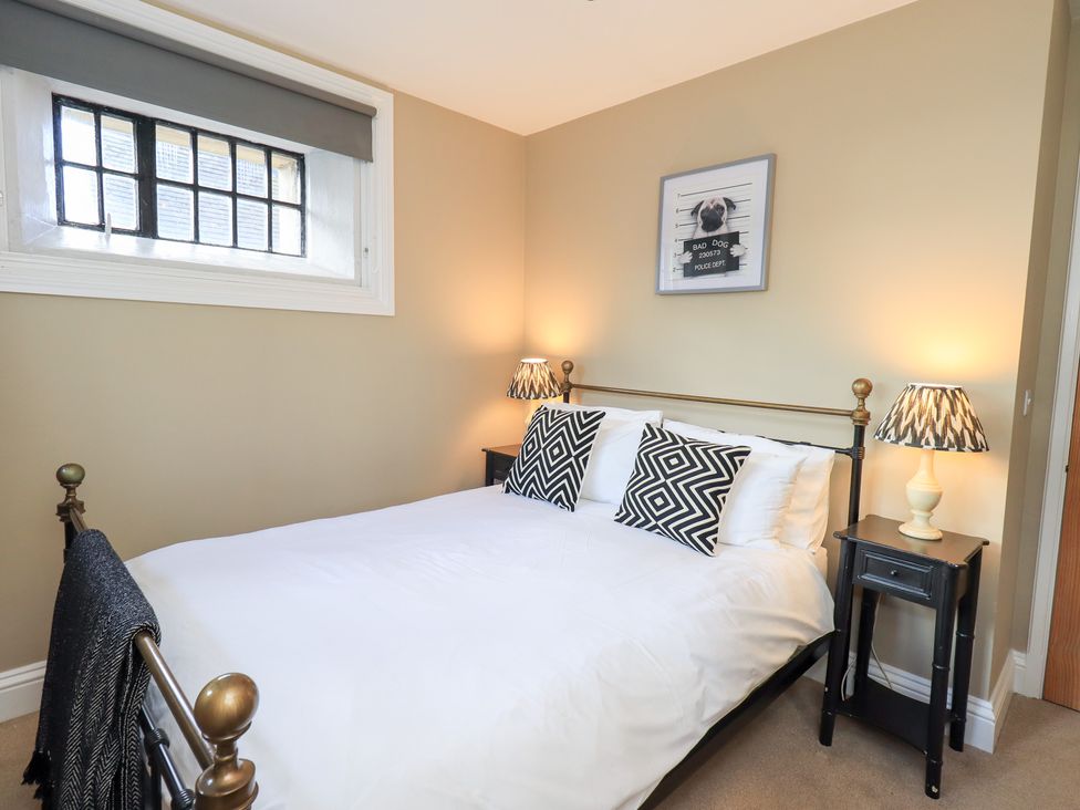 A bedroom with a bed, bedside tables, and lamps at The Cells in Ingleton