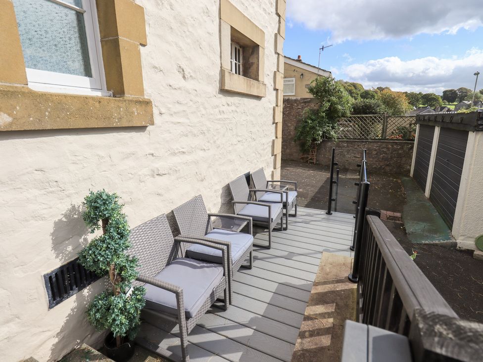 An outdoor area with chairs and a potted plant at The Cells in Ingleton