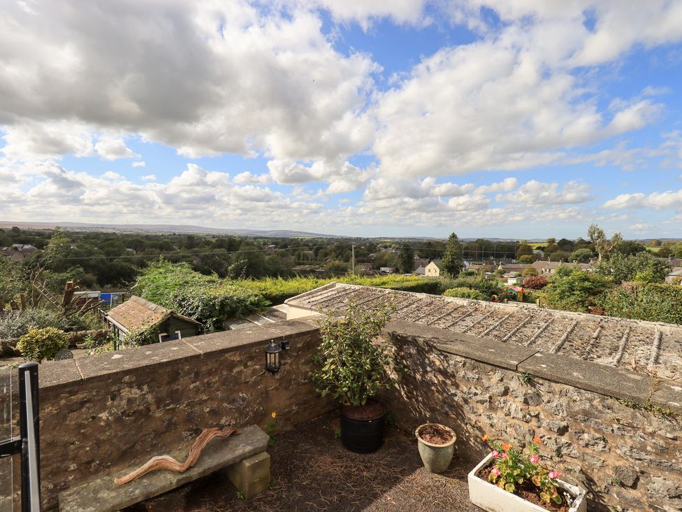 A view from a garden showing a landscape with plants and a stone wall at The Cells Ingleton