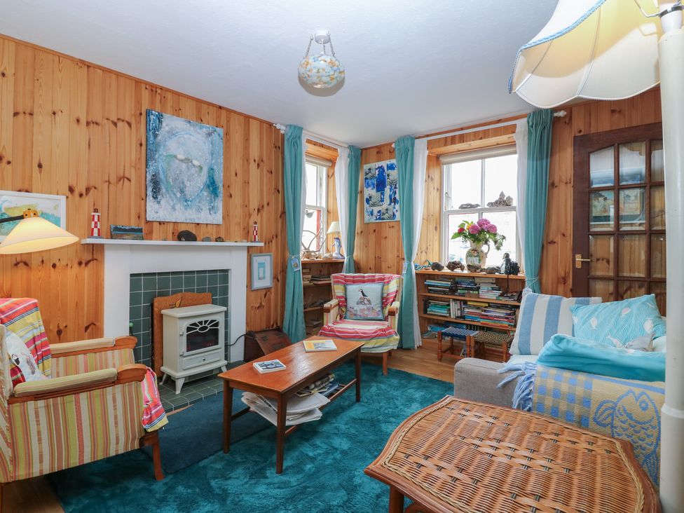 A living room with seating and a fireplace at Dookers Hoose in Cullen