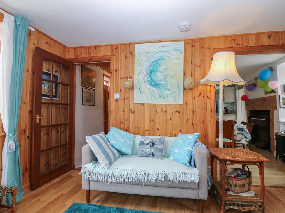 A living room with a sofa and lamp at Dookers Hoose Cullen