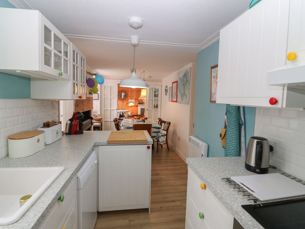 A kitchen with cabinets and dining area at Dookers Hoose Cullen