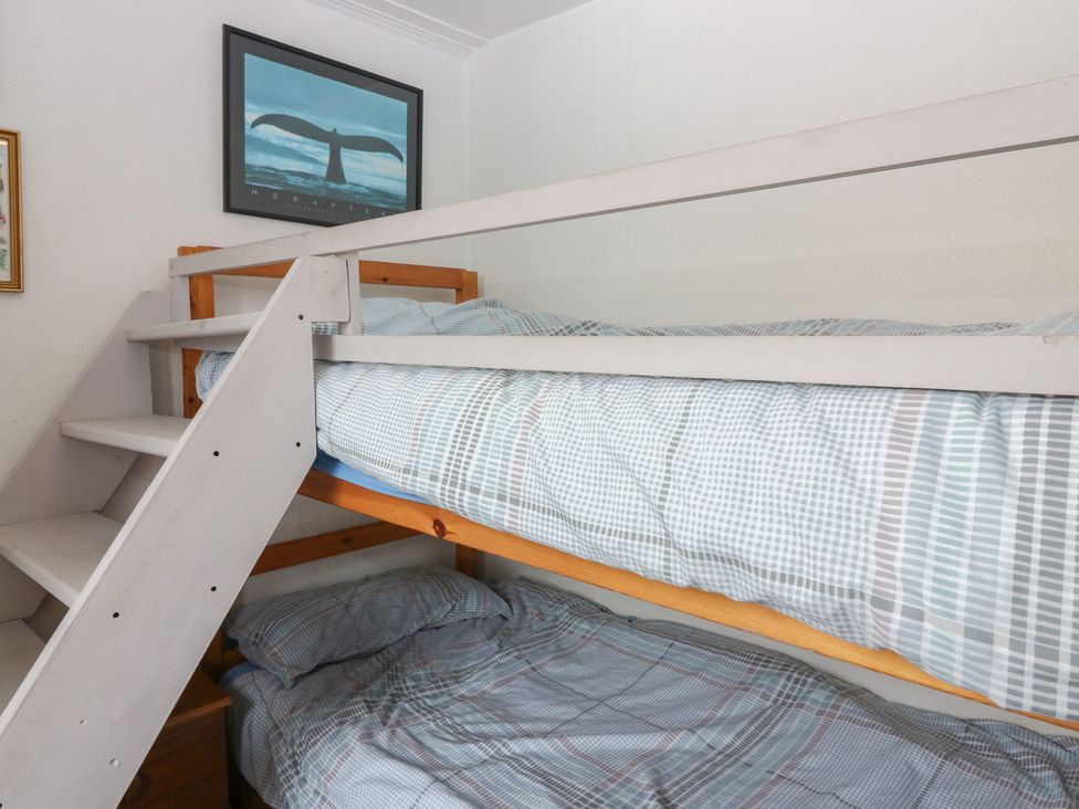 A bunk bed with plaid bedding in a bedroom at Dookers Hoose Cullen