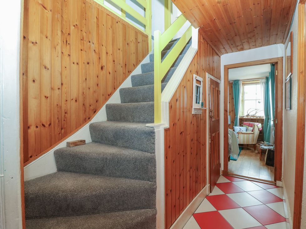 A hallway with stairs and a door at Dookers Hoose in Cullen