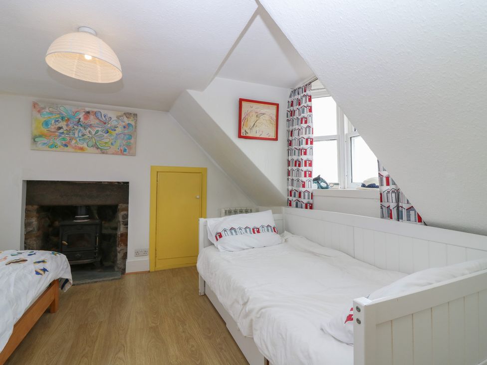 A bedroom with two beds and a fireplace at Dookers Hoose in Cullen