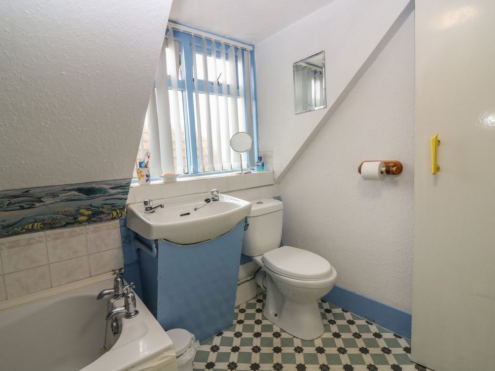 A bathroom with a bathtub, basin, and toilet at Dookers Hoose in Cullen
