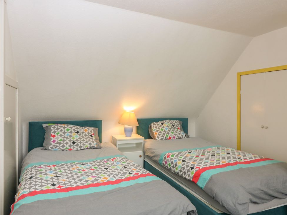A bedroom with two single beds and a nightstand at Dookers Hoose in Cullen