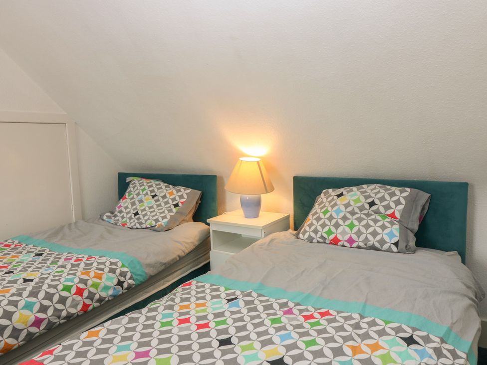 A bedroom with two beds and a lamp at Dookers Hoose Cullen