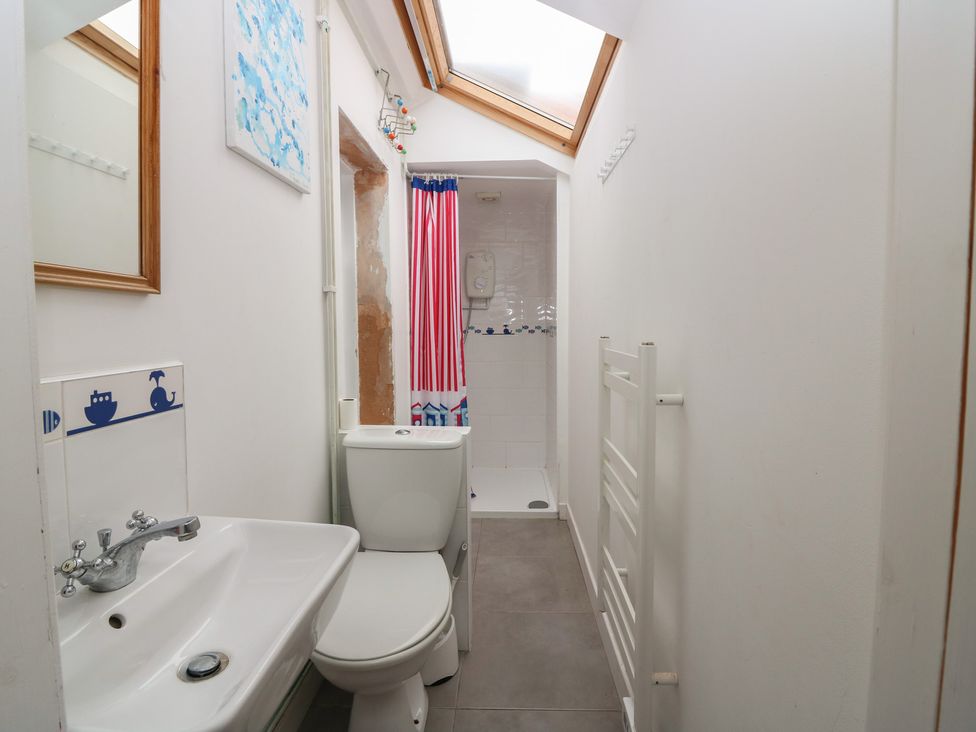 A bathroom with a toilet, sink, and shower at Dookers Hoose in Cullen